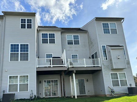 Technician soft washing vinyl siding on a santa rosa home